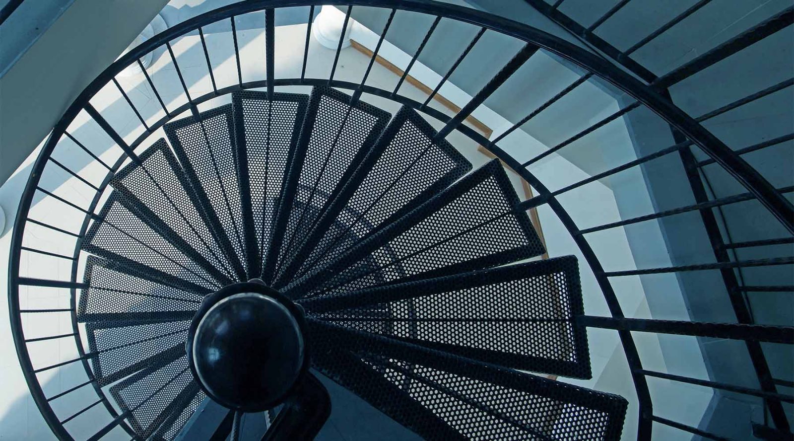 Spiral staircase viewed from above, representing complexity and progression.