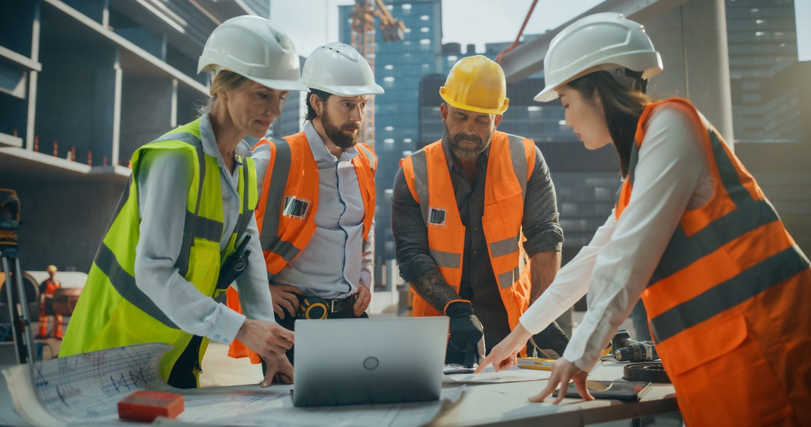 A team of construction professionals reviewing building plans at a commercial property site.