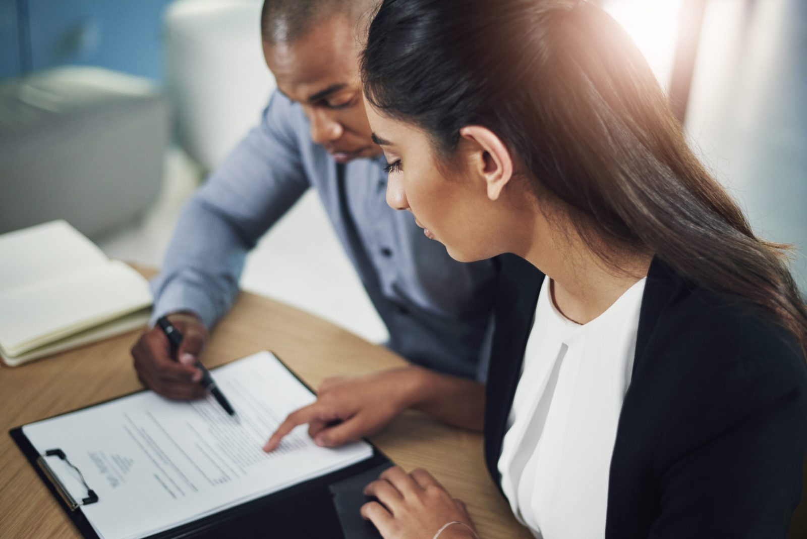 A professional writing a commercial contract in a boardroom.