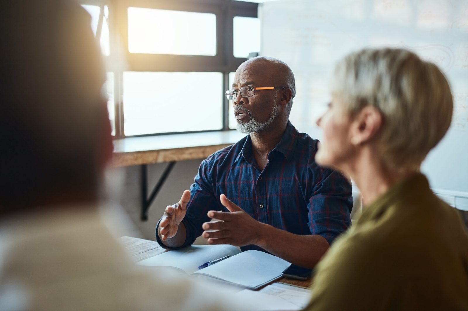 A group of professionals in discussion, symbolising workplace interactions and the legal implications of comments on protected characteristics.