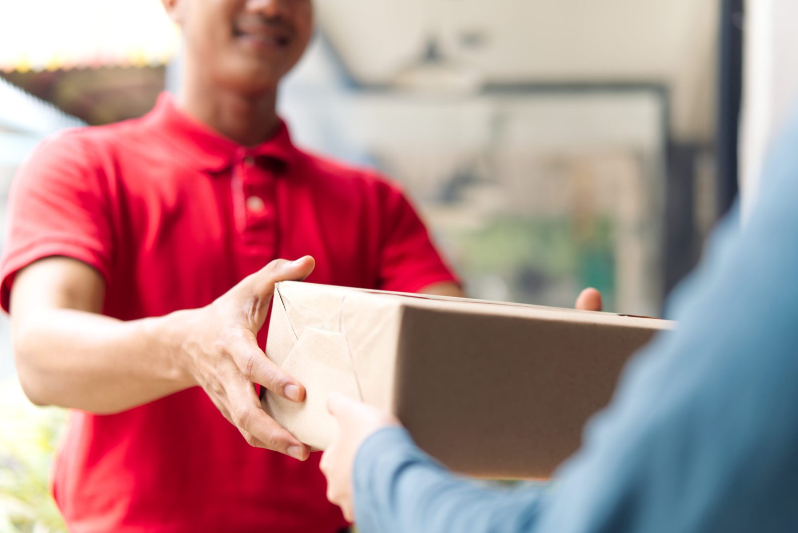 Postman delivering a package to a customer, highlighting the role of postal workers.