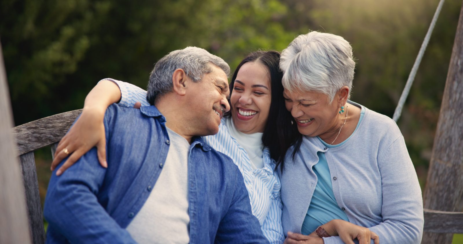 Adult daughter laughing with her elderly parents during a family gathering