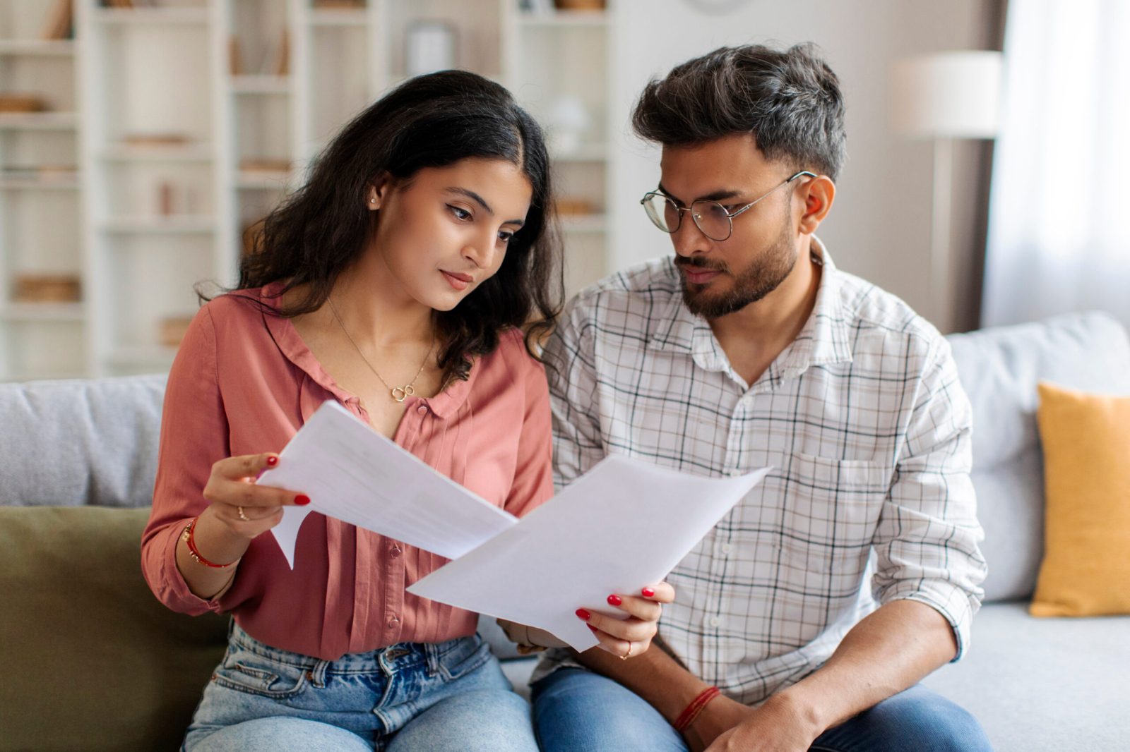 Focused Indian couple checking through their will documents in relation to a claim against their estate
