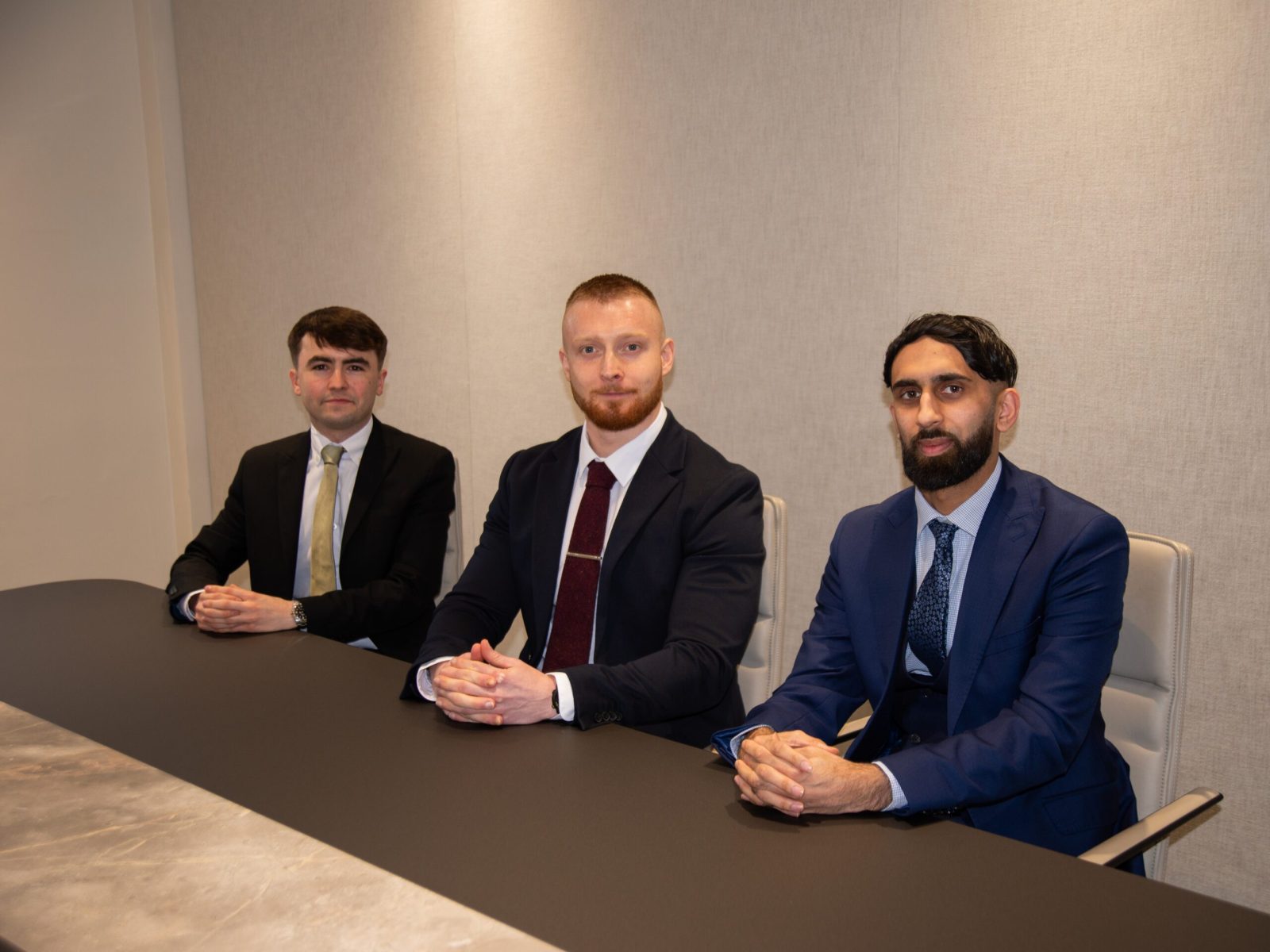 Harry Brogan, Sam Skelton and Raza Zahar in Flint Bishop conference room following qualification as solicitors.