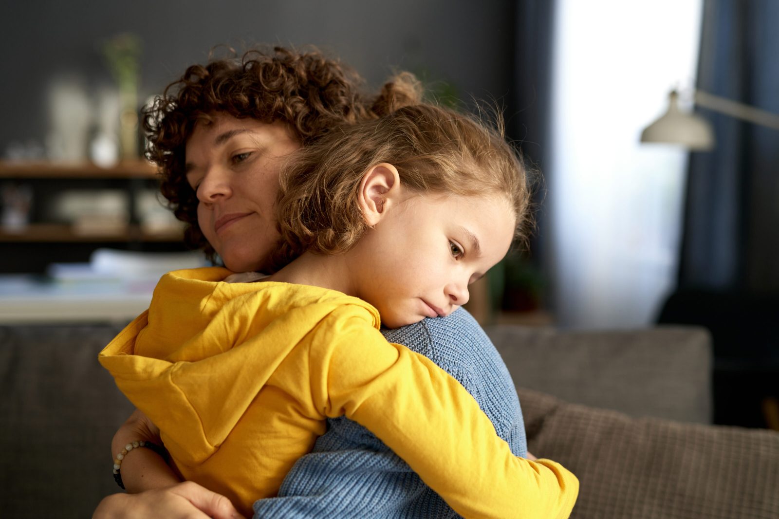 Sad child hugging her mother, reflecting emotional impact of family court decisions.
